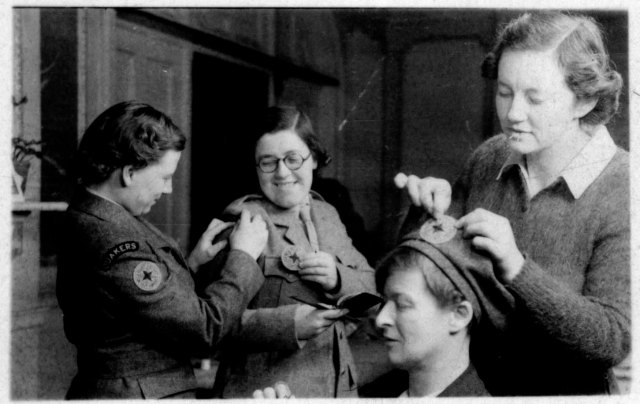 Friends Relief Workers pinning on badges at Friends House